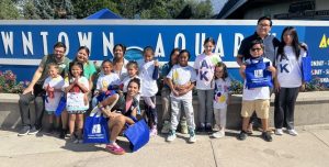 Kids and adults in front of Downtown Aquarium sign