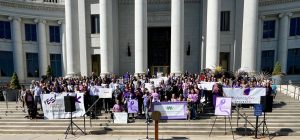 People raising awareness about domestic violence prevention month in front of the capital